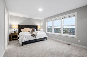 a bedroom with a bed and three windows
